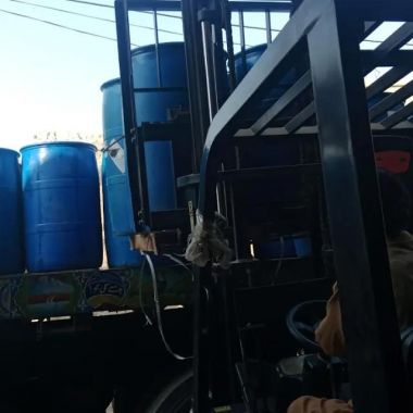 Blue Industrial Barrels Being Loaded onto Truck with Forklift